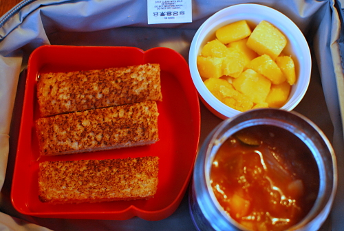 Homemade vegetable soup, cold grilled cheese sandwich strips for dipping, and frozen mango cubes.