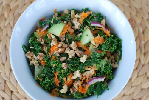Massaged kale salad with avocado & lemon, topped with carrots, red onion, cucumber, and toasted walnuts